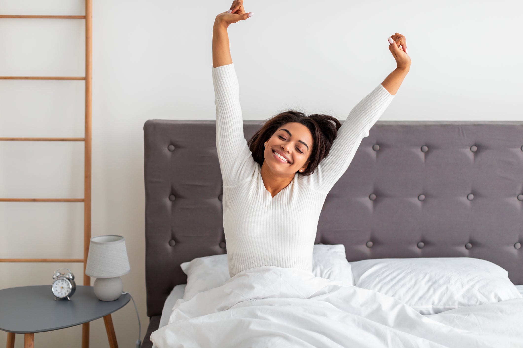 Woman stretching waking up in bed