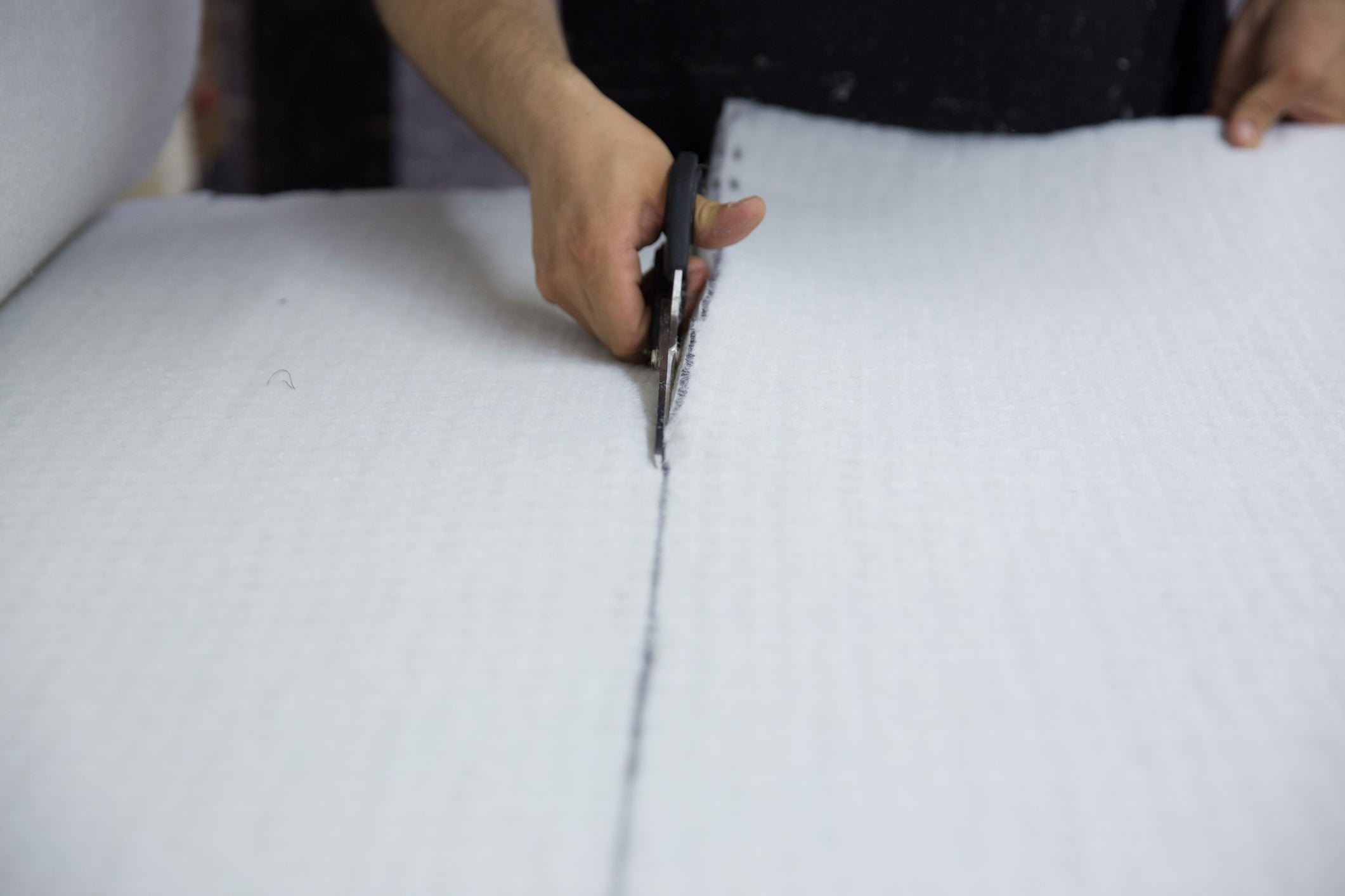 Person cutting through mattress pieces
